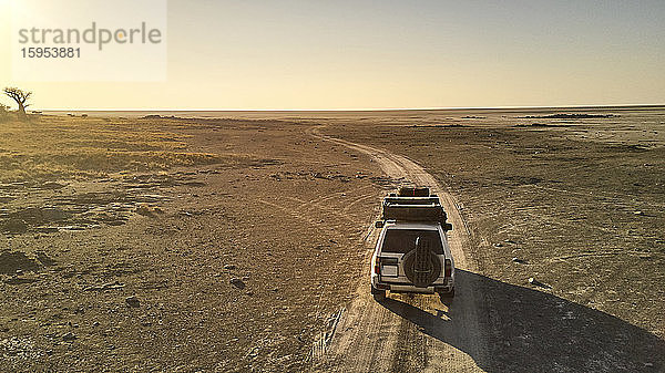 Botswana  Luftaufnahme eines 4x4-Autos bei der Überquerung von Makgadikgadi Pan in der Abenddämmerung