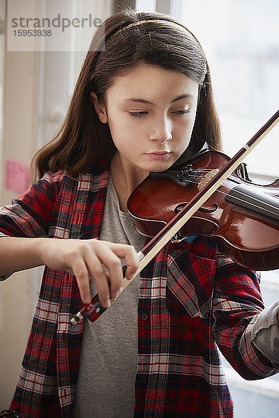 Mädchen spielt Geige während einer Unterrichtsstunde