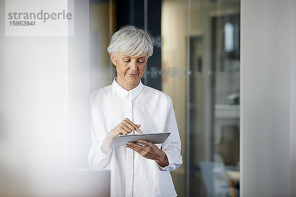 Portrait einer älteren Geschäftsfrau mit digitalem Tablet im Büro