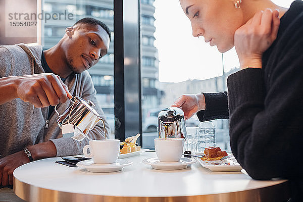 Junges Paar in einem Café bei Kuchen und Tee