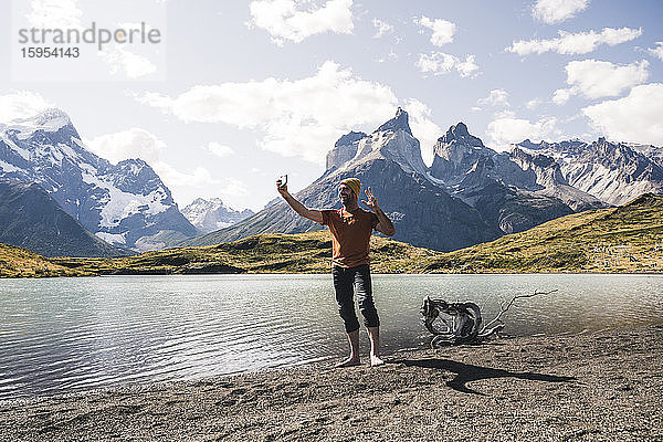 Glücklicher Mann beim Selfie am Seeufer im Nationalpark Torres del Paine  Patagonien  Chile