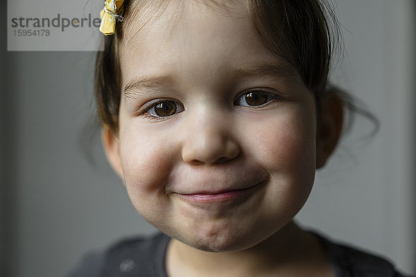 Bildnis eines lächelnden kleinen Mädchens mit braunen Augen
