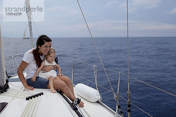 Mutter und ihre Tochter sitzen während des Segeltörns auf dem Bootsdeck