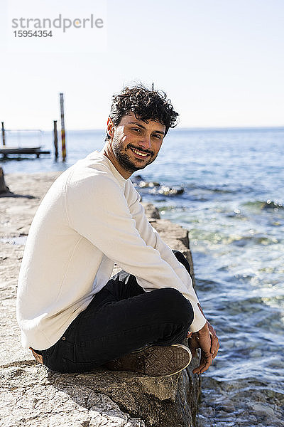 Porträt eines lächelnden jungen Mannes am Gardasee  Italien