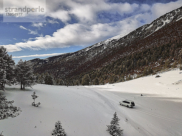 Spanien  Asturien  Cornellana  4x4-Auto fährt über ein schneebedecktes Bergtal