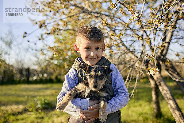 Porträt eines Jungen mit Hund auf einer Wiese