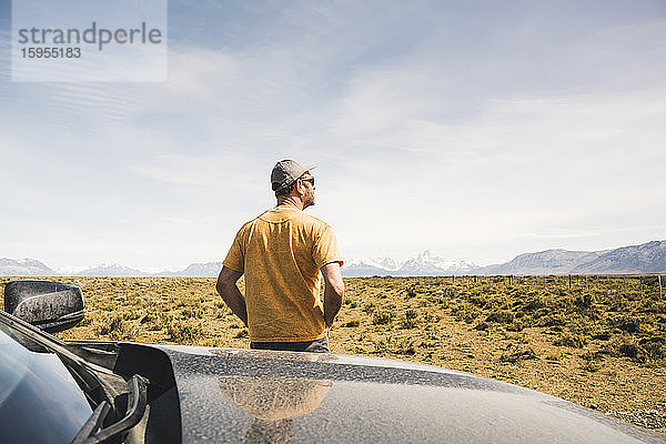 Rückansicht eines Mannes am Auto in einer abgelegenen Landschaft in Patagonien  Argentinien
