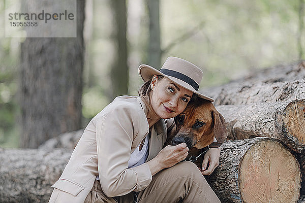 Porträt einer eleganten Frau und ihres Hundes im Wald