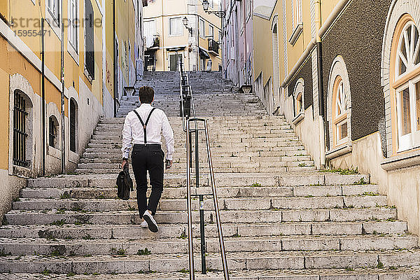Rückansicht eines jungen Mannes beim Treppensteigen in der Altstadt  Lissabon  Portugal