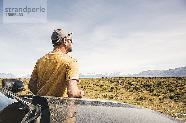 Rückansicht eines Mannes am Auto in einer abgelegenen Landschaft in Patagonien  Argentinien