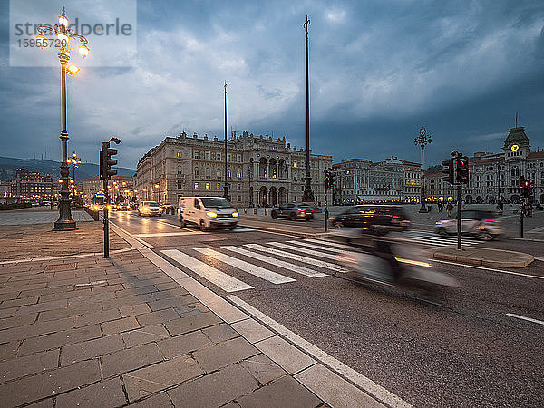 Italien  Provinz Triest  Triest  Verkehr auf der Piazza dellUnita dItalia in der Abenddämmerung