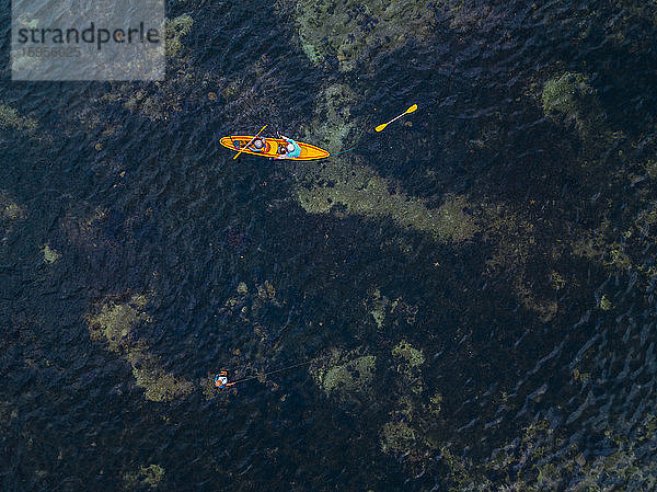 Indonesien  Bali  Sanur  Luftaufnahme von zwei Kajakfahrern  die an einem Mann vorbeifahren  der im flachen Wasser fischt