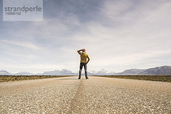 Mann steht auf einer Straße in einer abgelegenen Landschaft in Patagonien  Argentinien