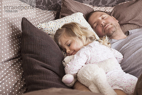 Vater und Tochter schlafen im Bett