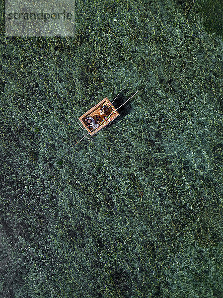 Indonesien  Bali  Nusa Dua  Luftaufnahme von zwei Personen  die auf einem Boot in der Nähe des Gunung Payung Strandes fischen