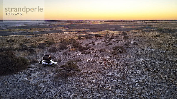 Botswana  Luftaufnahme eines 4x4-Autos bei der Überquerung von Makgadikgadi Pan in der Abenddämmerung