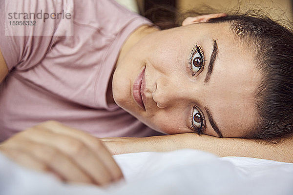Bildnis einer auf dem Bett liegenden jungen Frau mit braunen Augen
