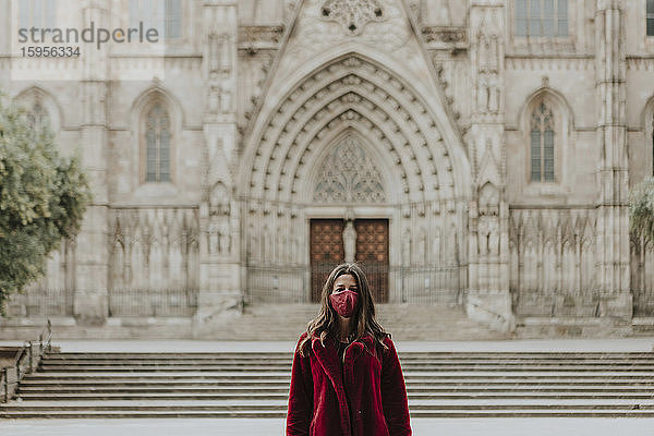 Porträt einer Frau mit Gesichtsmaske  die während der Quarantäne vor der Kathedrale von Barcelona steht  Barcelona  Spanien