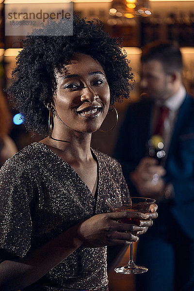 Porträt einer jungen Frau bei einem Cocktail in einer Bar