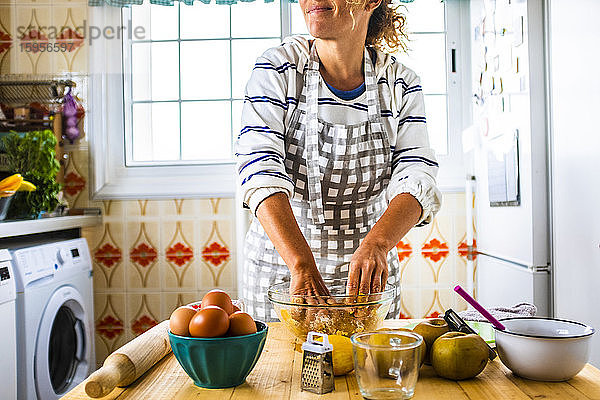 Frau bereitet in ihrer Küche einen Kuchen zu