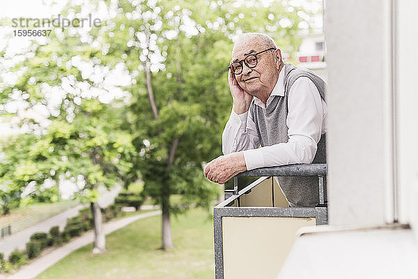 Porträt eines lächelnden älteren Mannes auf dem Balkon