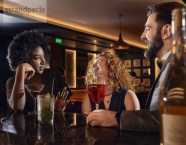 Glückliche Freunde beim Cocktail in einer Bar