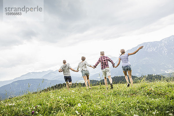 Freunde laufen auf einer Wiese in den Bergen  Achenkirch  Österreich