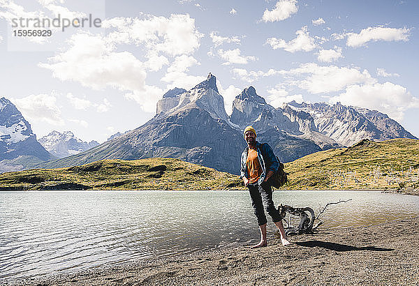 Glücklicher Mann in einer Berglandschaft am Seeufer im Nationalpark Torres del Paine  Patagonien  Chile
