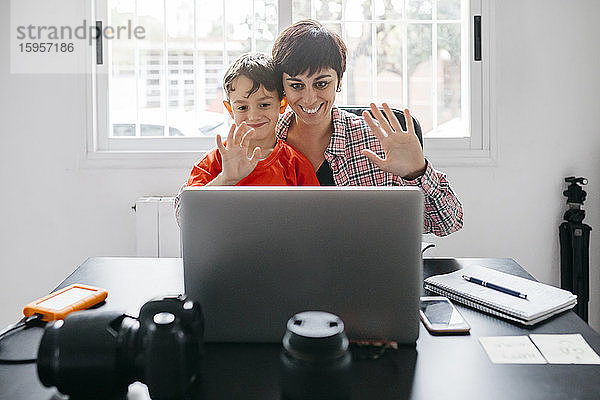 Mutter und Sohn nutzen Laptop für einen Videoanruf zu Hause