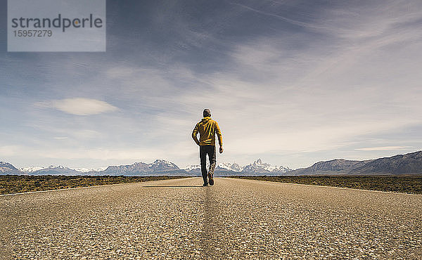 Mann geht auf einer Straße in einer abgelegenen Landschaft in Patagonien  Argentinien