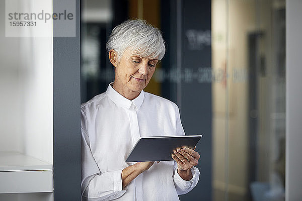 Portrait einer älteren Geschäftsfrau mit digitalem Tablet im Büro