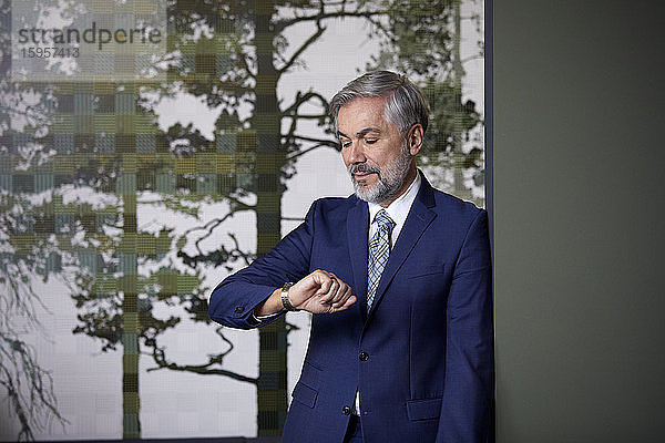 Reifer Geschäftsmann im Amt  der die Zeit überprüft