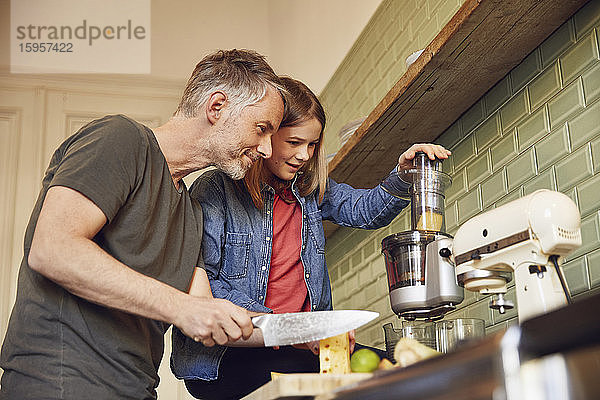 Vater und Tochter in der Küche beim Zubereiten eines Smoothie