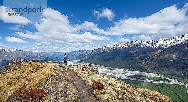 Panoramablick  Wanderer auf dem Berggipfel von Mount Alfred  Ausblick auf Lake Wakatipu und Berglandschaft  Glenorchy bei Queenstown  Südliche Alpen  Otago  Südinsel  Neuseeland  Ozeanien
