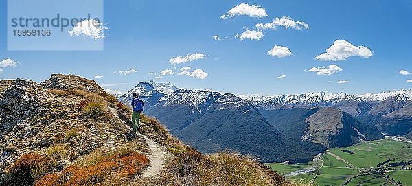 Wanderer auf dem Berggipfel von Mount Alfred  Ausblick auf schneebedeckte Berglandschaft  Glenorchy bei Queenstown  Südliche Alpen  Otago  Südinsel  Neuseeland  Ozeanien