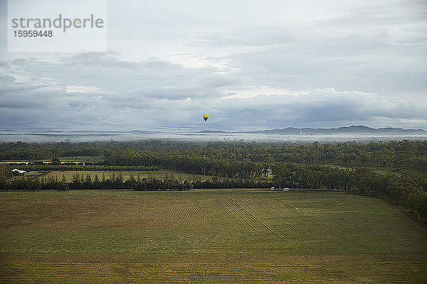 Landschaft in der Nähe von Cairns  Australien  mit einem Heißluftballon in der Ferne.