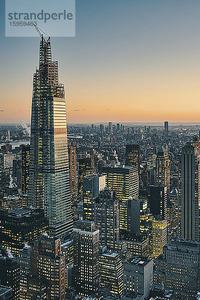 Blick auf die Skyline von Manhattan mit beleuchteten Wolkenkratzern bei Sonnenuntergang  New York City