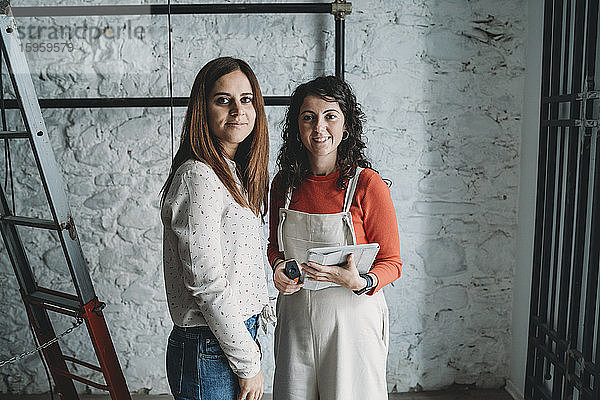 Zwei mittelgroße erwachsene Frauen bei der Vorbereitung ihres neuen Geschäfts  Porträt