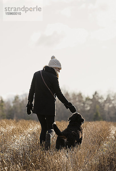 Eine Frau geht mit ihrem Berner Sennenhund spazieren.
