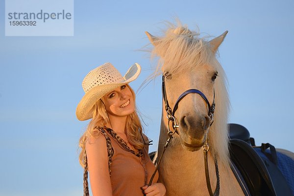 Lächelnde Frau mit Pferd unter blauem Himmel  Portrait