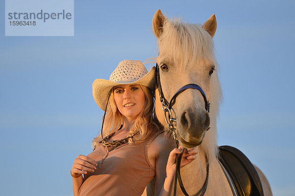 Lächelnde Frau mit Pferd unter blauem Himmel  Portrait