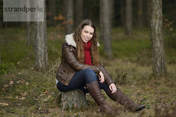 Lächelnde junge Frau im Wald