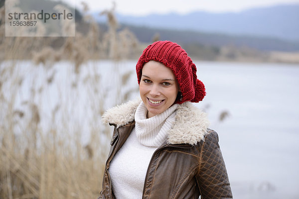Lächelnde junge Frau an einem See  Porträt