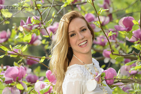 Junge Frau an einer blühenden Magnolie  Portrait