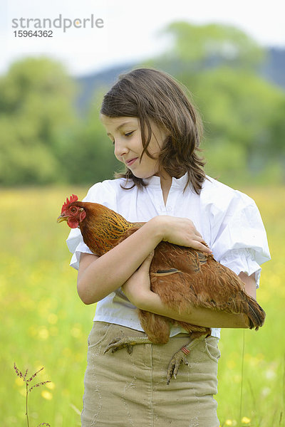 Mädchen hält ein Huhn