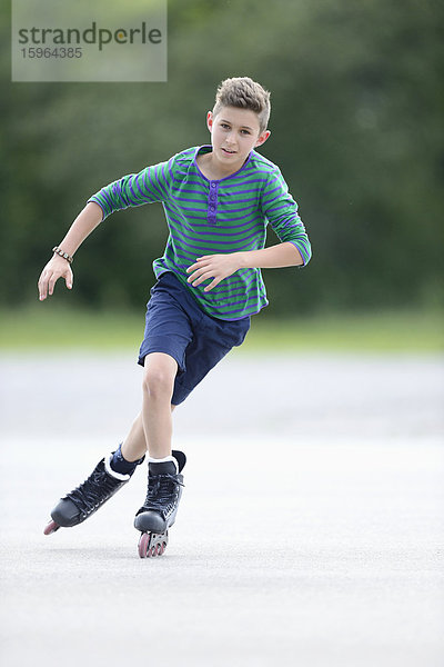 Junge mit Inline-Skates auf einem Sportplatz