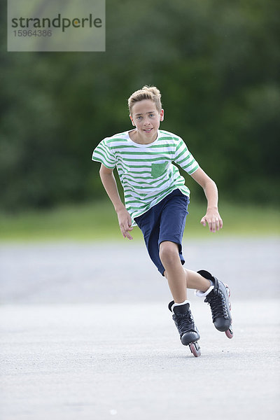 Junge mit Inline-Skates auf einem Sportplatz