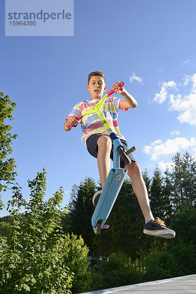 Junge mit Kickboard in einem Skatepark