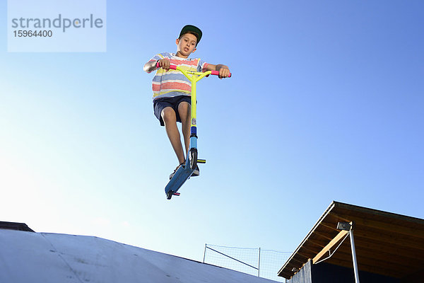 Junge mit Kickboard in einem Skatepark