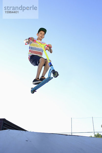 Junge mit Kickboard in einem Skatepark